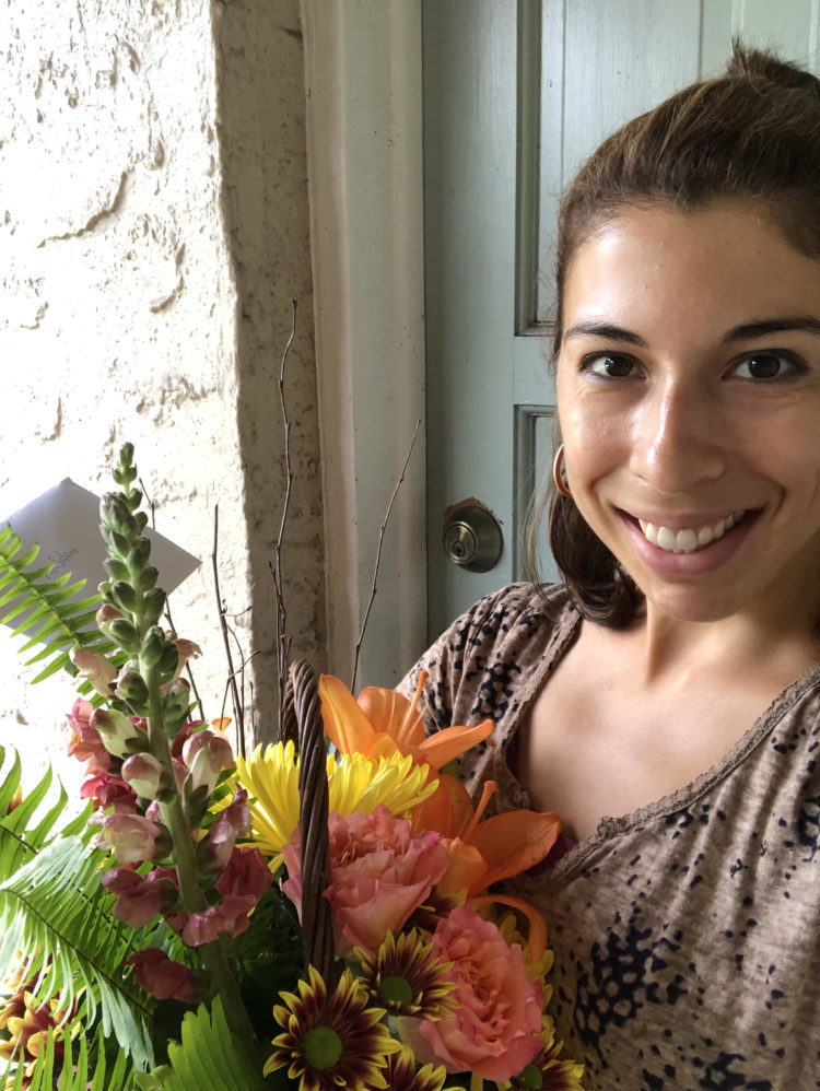 Teacher, Gabriela Solano smiling and holding flowers