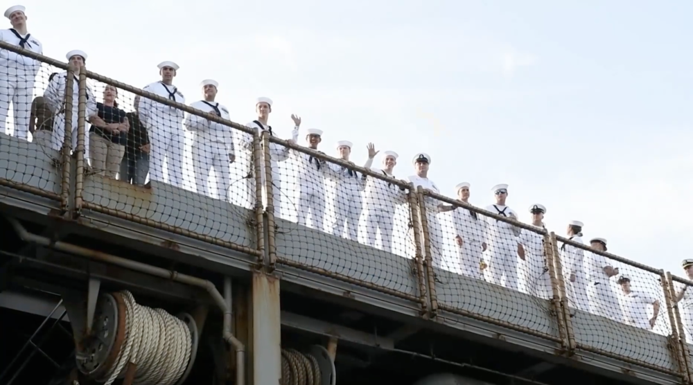 A group of sailors waves on the pier of NAS Mayport.
