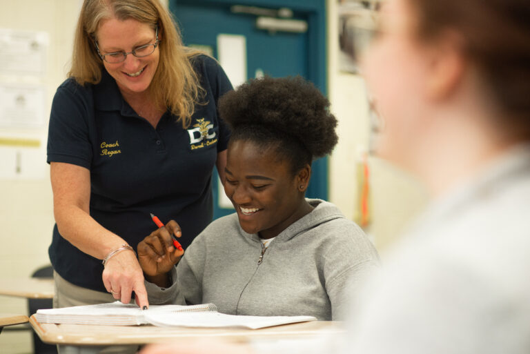 smiling teacher and student at classroom