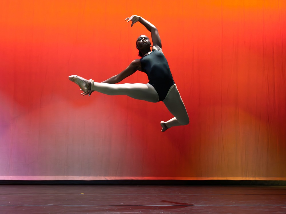 Image of ballet student leaping in air during a dance performance.