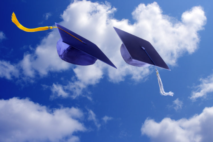 Image of two graduation caps in the air