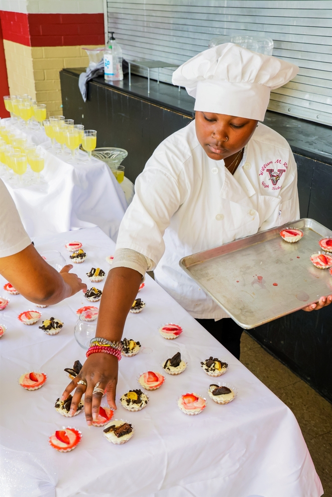 Culinary Student Placing Food on a Table 