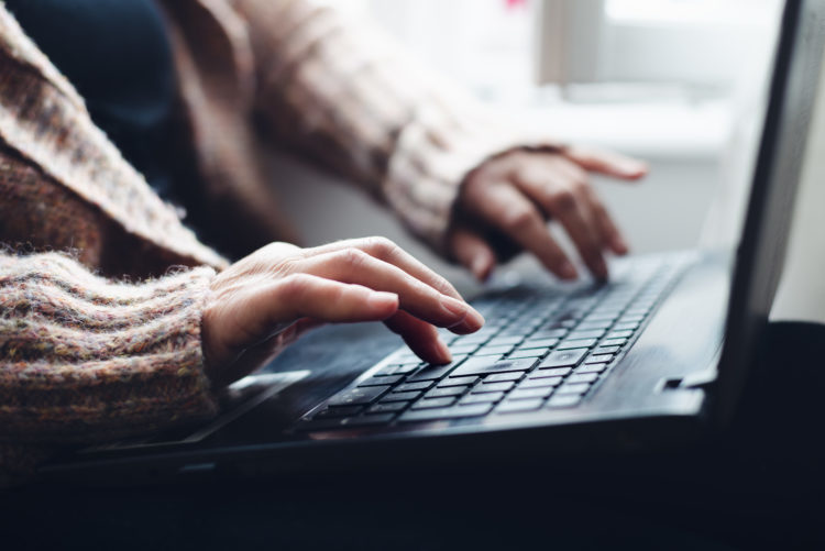 Closeup of hands typing on a laptop