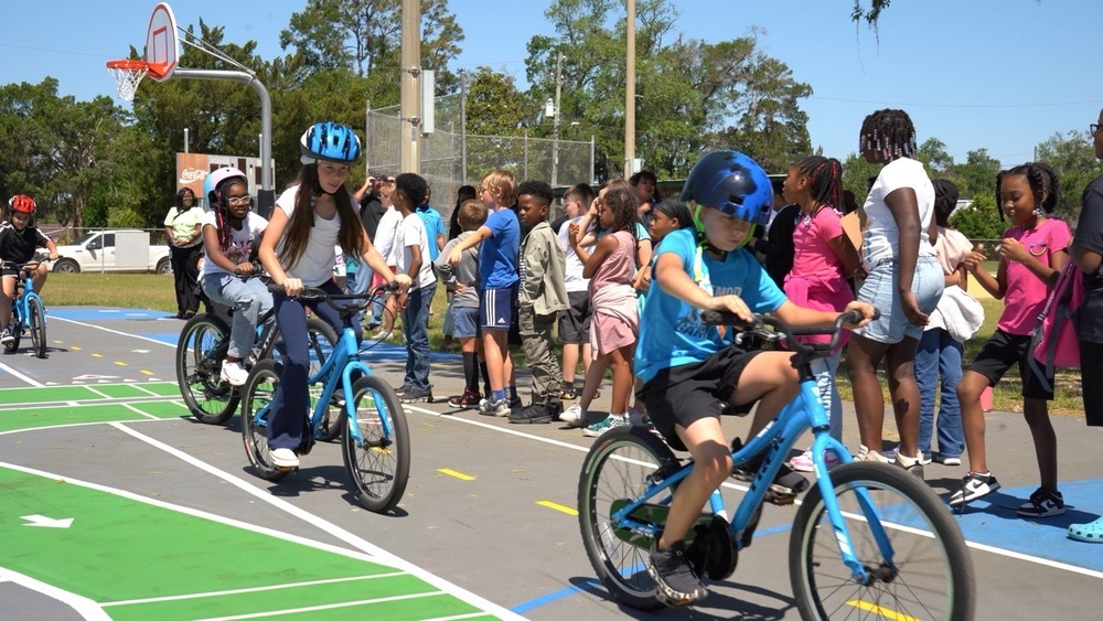 A group of students on bicycles circle the traffic garden at San Mateo Elementary.