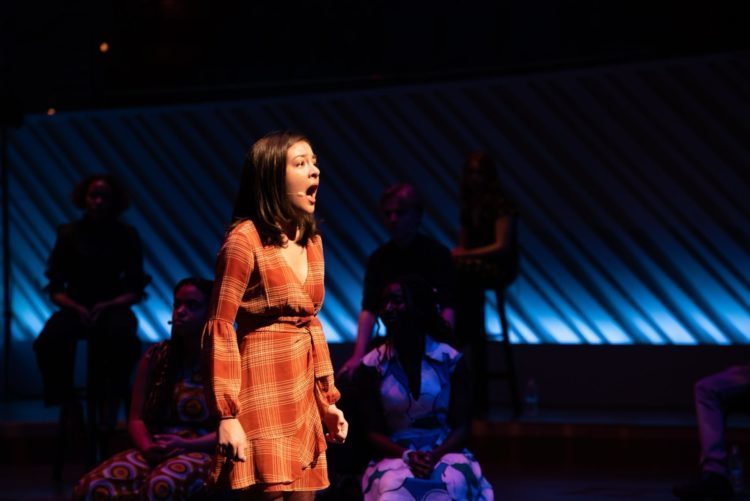 Student in spotlight singing on stage 