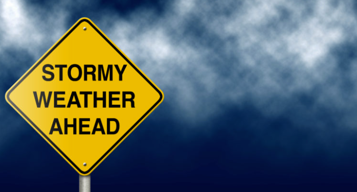 Caution sign with the words "Stormy Weather Ahead" in front of a storm