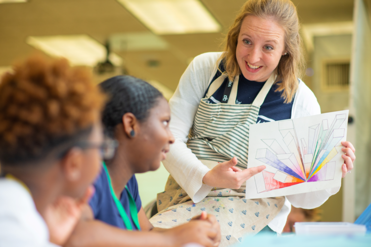 Teacher showing drawing to students