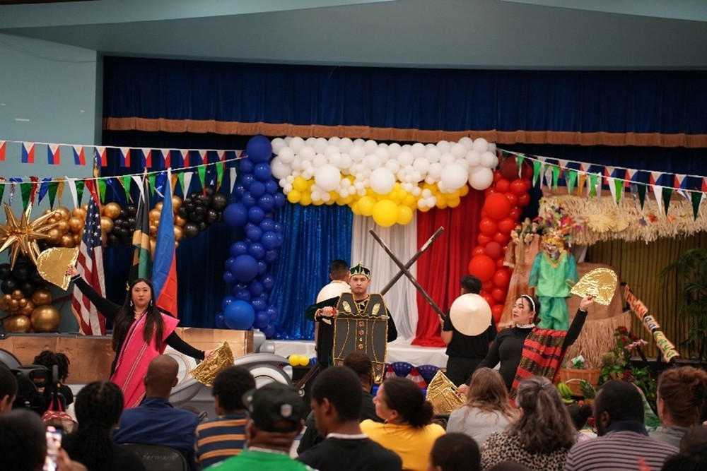 Filipino Teachers perform in colorful cultural attire on a decorated stage