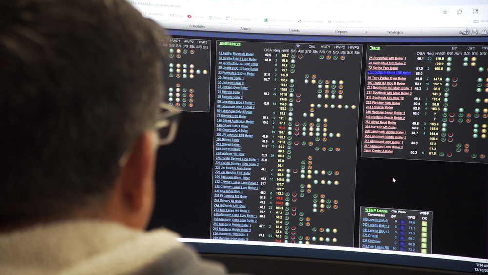 District facilities employee reviewing HVAC units by school on his computer