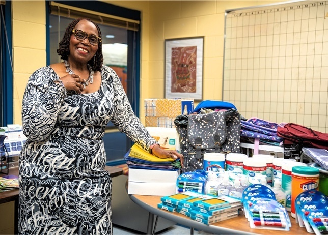 Parent Barbara Jones standing next to a table full of school supplies