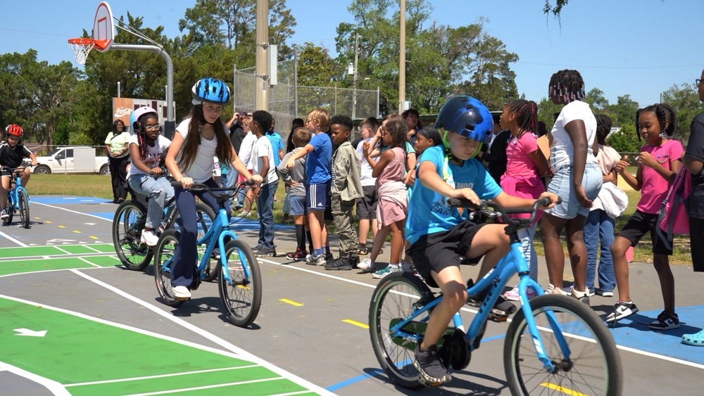 A group of students on bicycles circle the traffic garden at San Mateo Elementary.