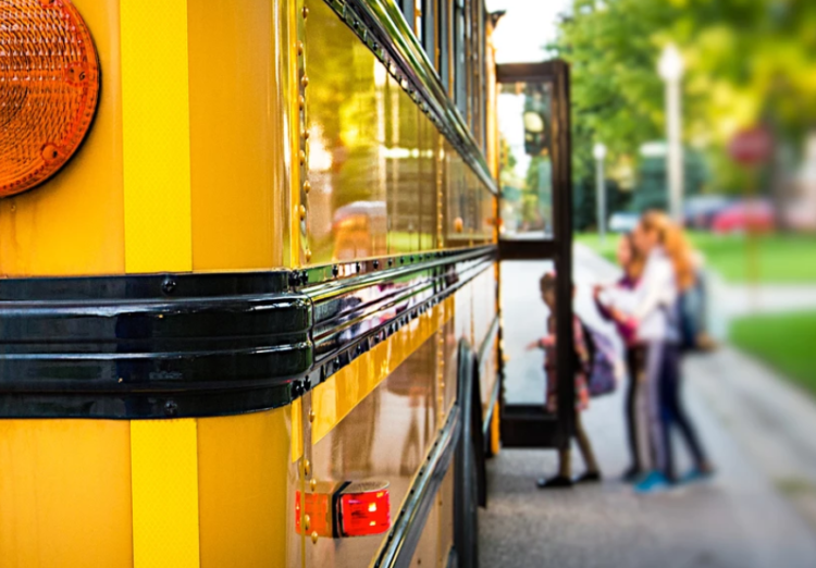 3 kids getting into a bus