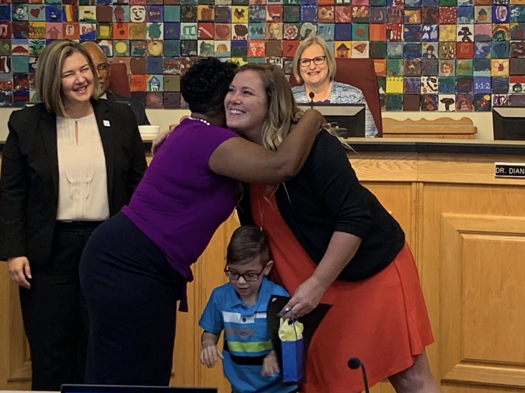 superintendent hugging teacher