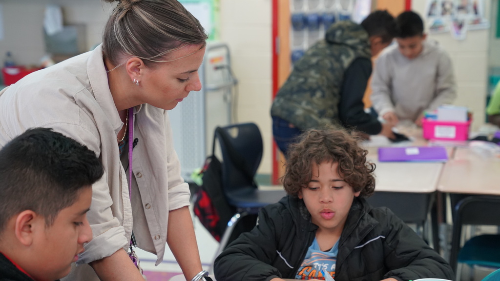 Lori Matthews smiles while leading a math activity in her 5th grade classroom at San Jose Elementary, surrounded by engaged students.