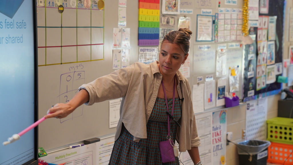 Lori Matthews smiles while leading a math activity in her 5th grade classroom at San Jose Elementary, surrounded by engaged students.