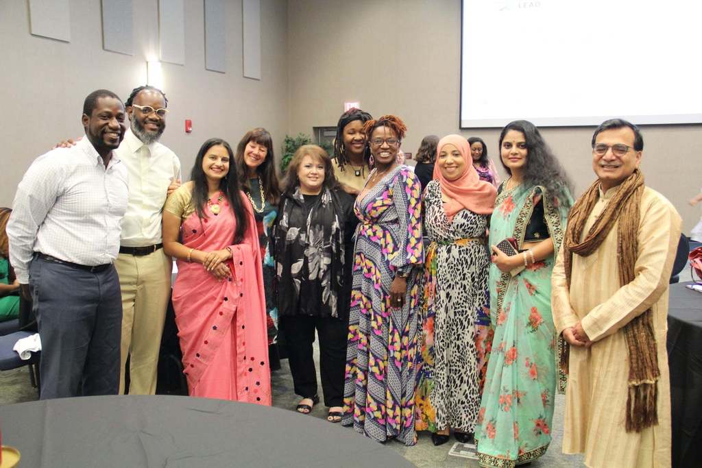 A group of parents from the "Parents Who Lead" program stand together and smile at the camera.