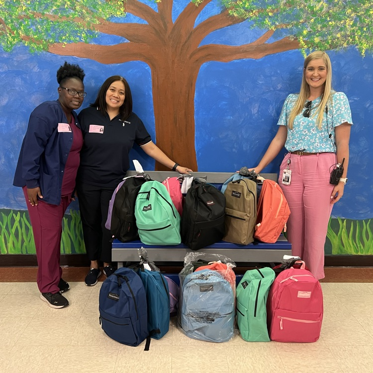 three women standing with backpacks 