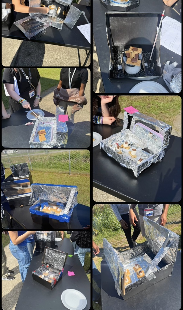 Students at outdoor tables display homemade solar ovens built from cardboard boxes lined with foil, each filled with marshmallows, graham crackers, and chocolate to make s’mores.