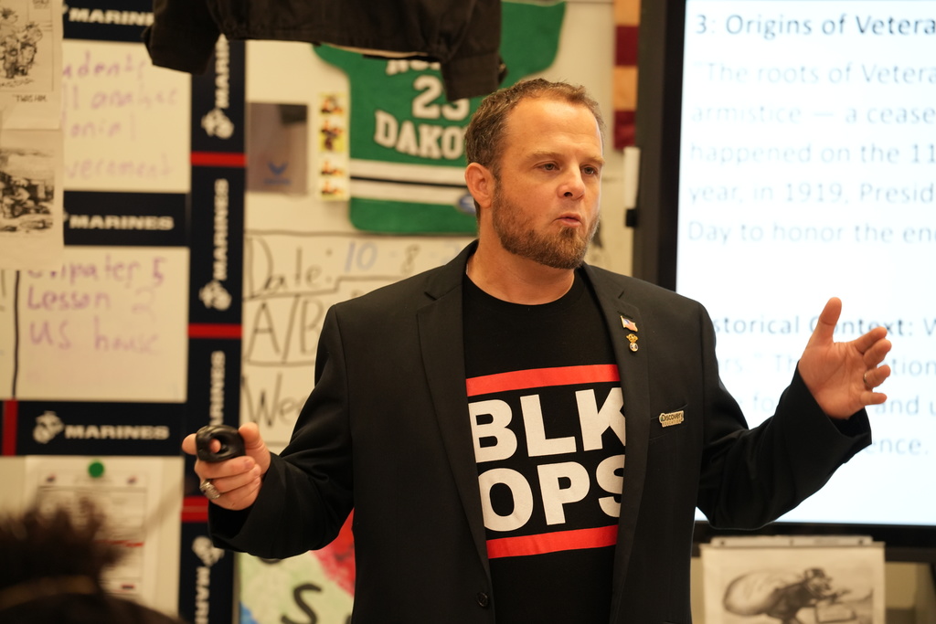 Daniel Flint speaks to Westside High School students during the Veterans Day Road Show, emphasizing the meaning of service and sacrifice.