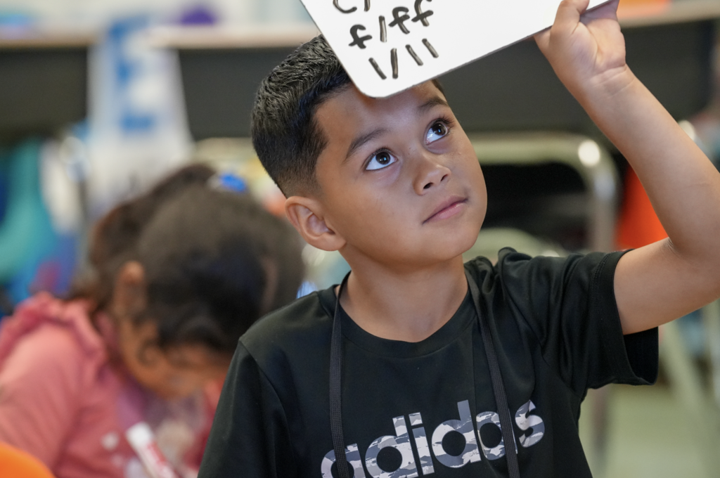 Two young students laugh together while practicing English vocabulary during class at Englewood Elementary.