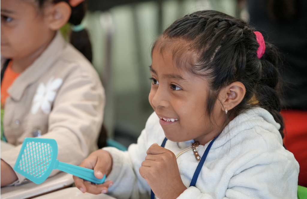 Two young students laugh together while practicing English vocabulary during class at Englewood Elementary.