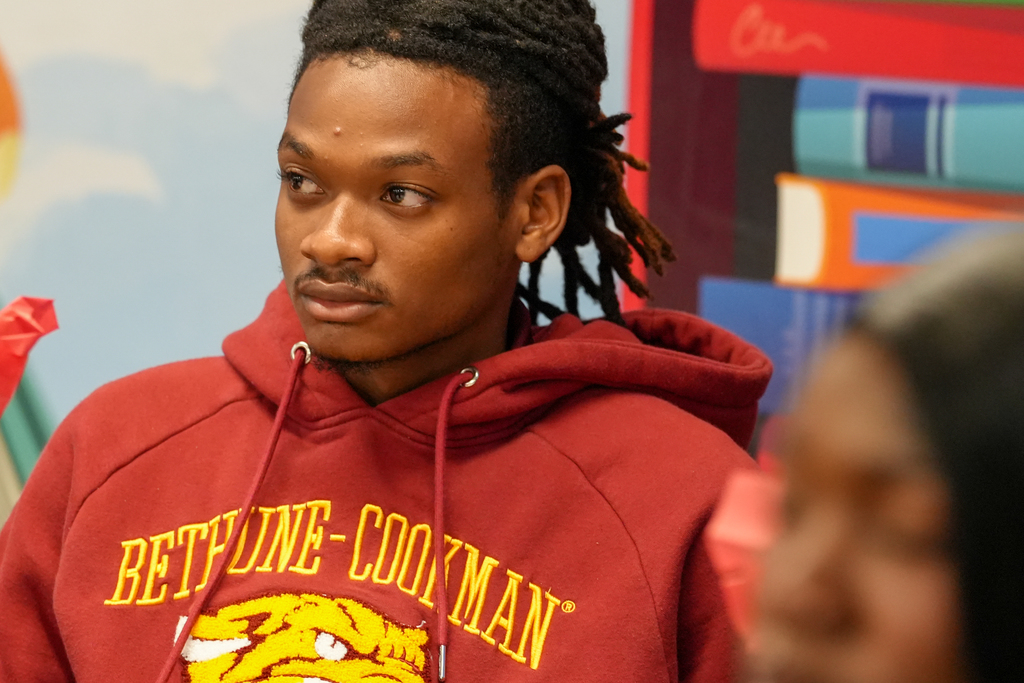 A Bethune-Cookman University student in a maroon B-CU sweatshirt sits attentively during the classroom visit.