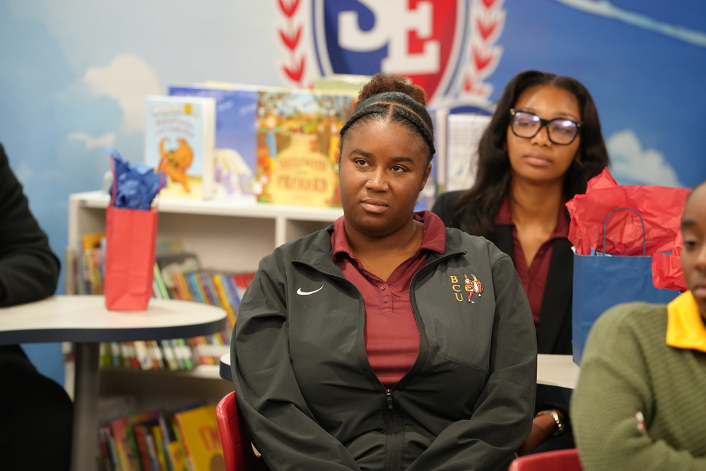 A Bethune-Cookman University student in a maroon B-CU sweatshirt sits attentively during the classroom visit.