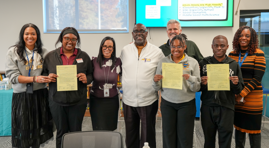 Bethune-Cookman University students and DCPS staff pose together as three Elementary Education majors hold open contract forms confirming they will join Duval County Public Schools after graduation.