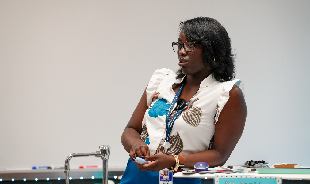 Stephanie Jenkins stands and observing and assisting during a hands-on activity.
