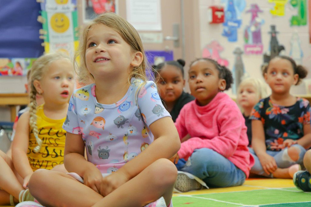 Six girl students sitting on the classroom floor