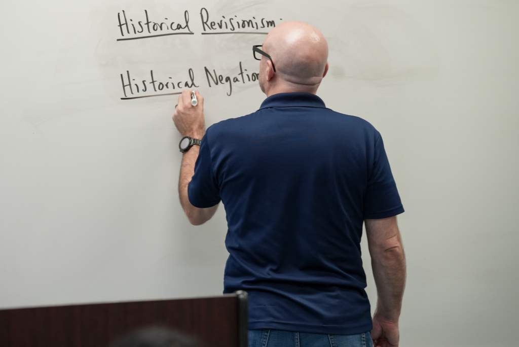 Kevin Smith walks down a classroom aisle at Paxon School for Advanced Studies.