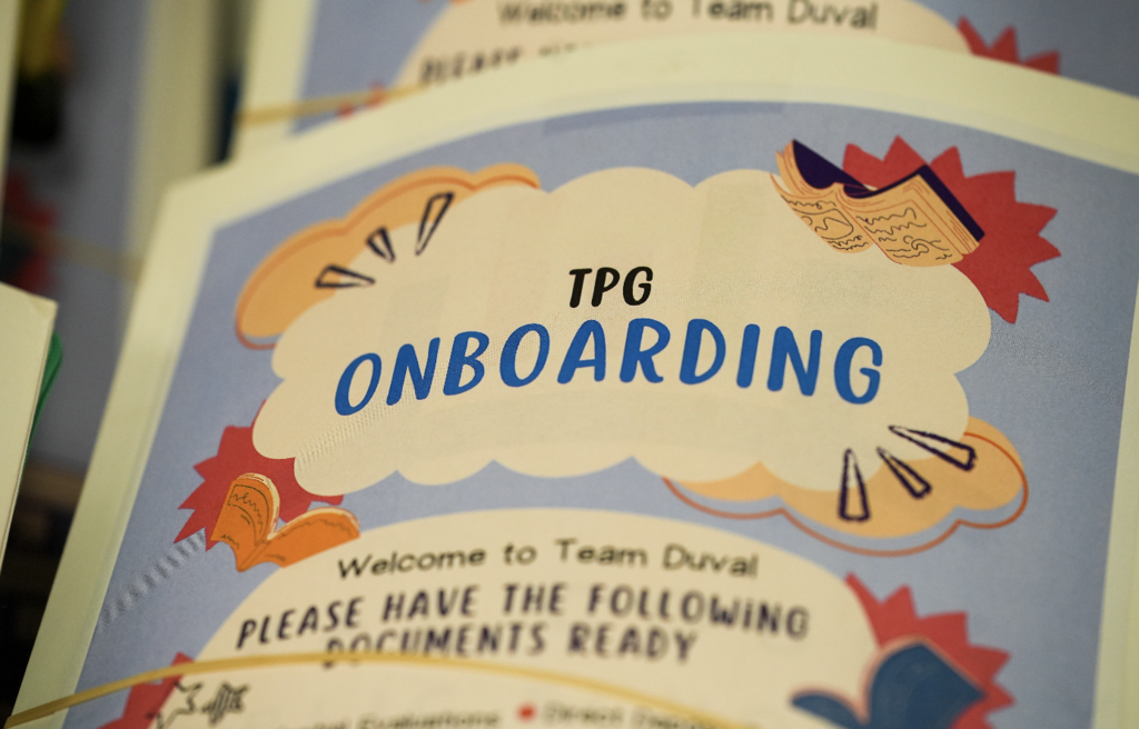 Printed sign reading “TPG Onboarding” displayed on a table during an onboarding event for new international teachers with Duval County Public Schools.