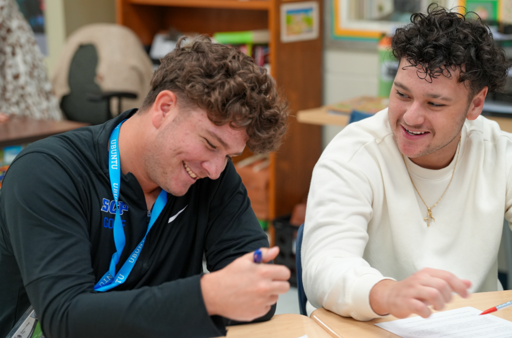 Two students work together at a desk, smiling and collaborating on an assignment during Norma Crespo-Lowery’s Spanish class.