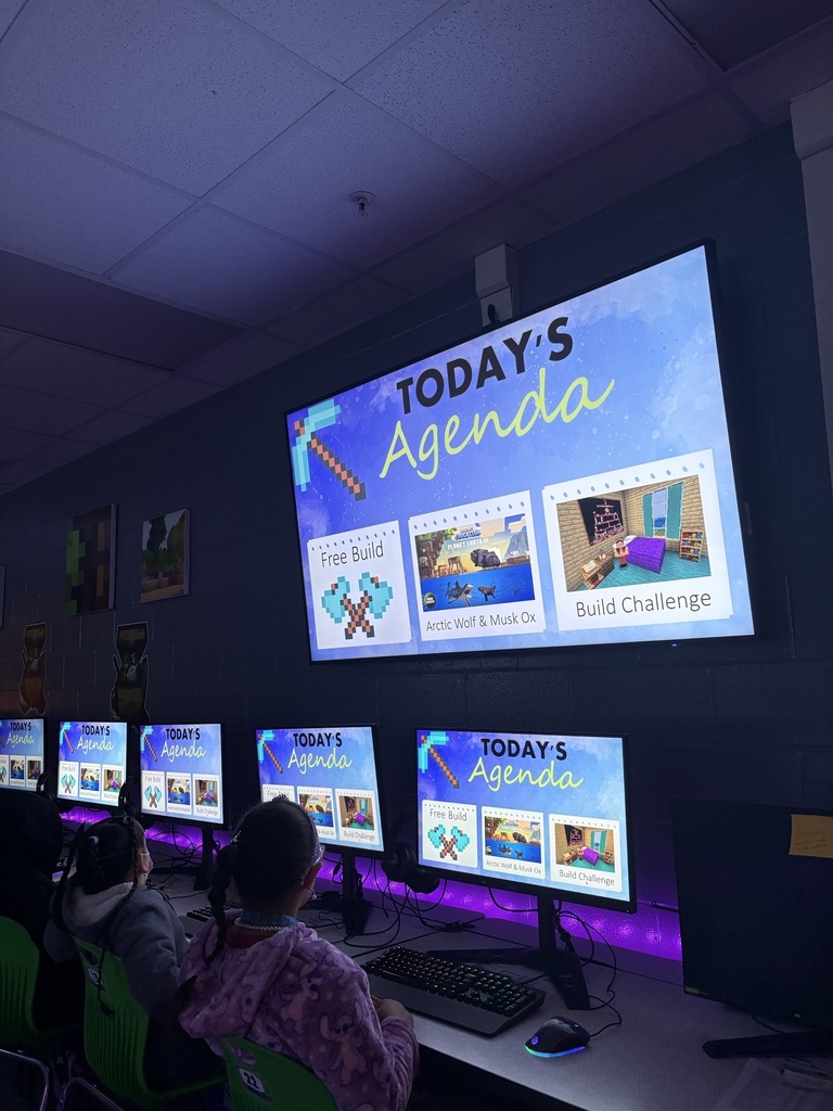 computer monitors with agenda for the day posted