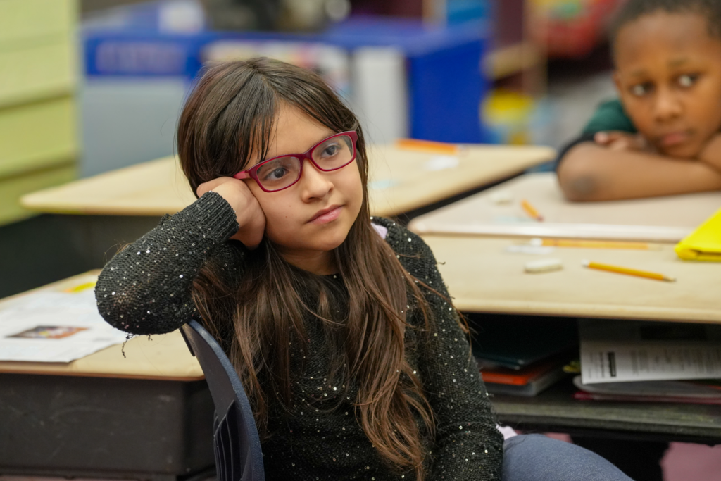 A student sits quietly at a desk, focused on the reading taking place during Real Men Read.