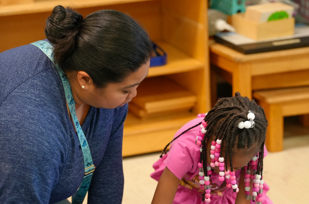 Erika Cunamay guiding a student during a hands-on Montessori lesson.