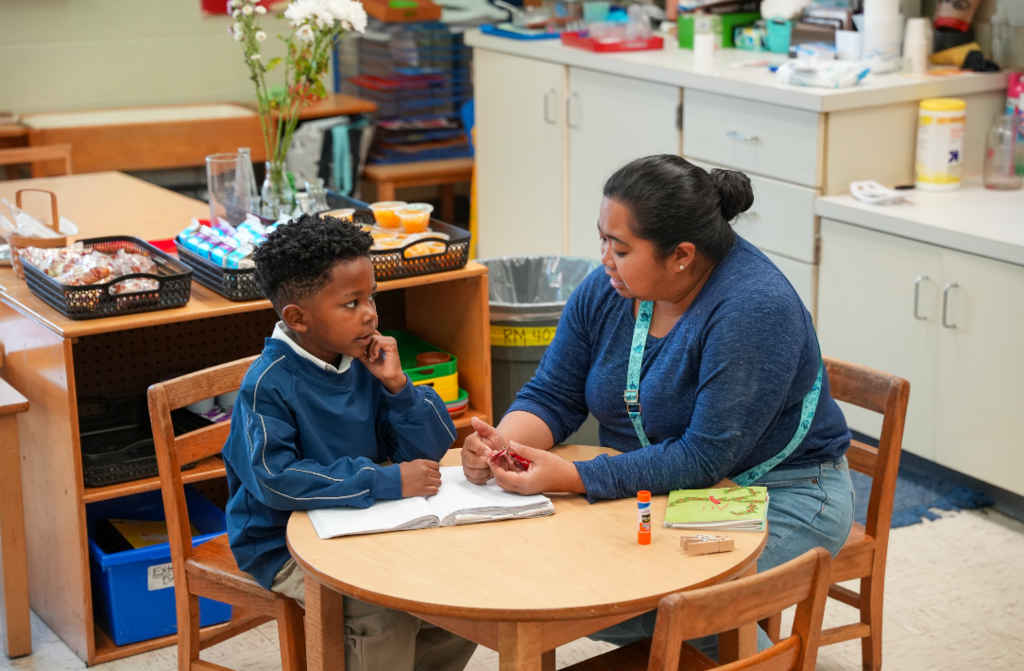 Students working together at a classroom table using Montessori materials.