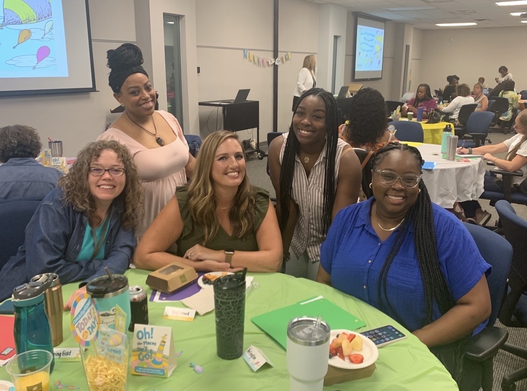 Five school social workers gather around a table and pose for a picture during a work conference. 