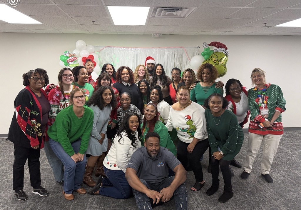 A group of school social workers pose for a photo duirng a Grinch-themed event.