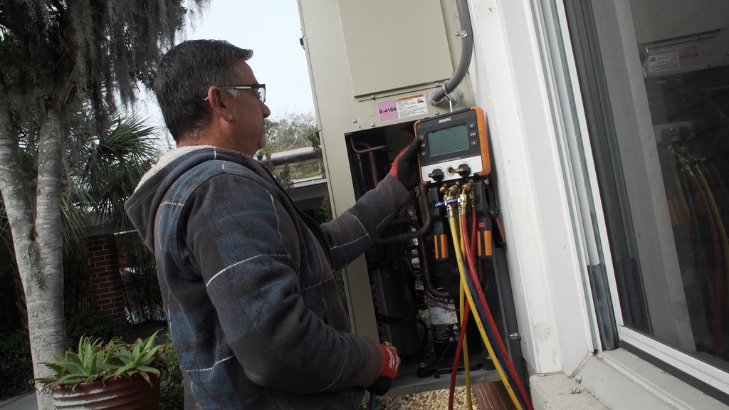 A medium shot of a maintenance worker reviewing data on a gadgette.