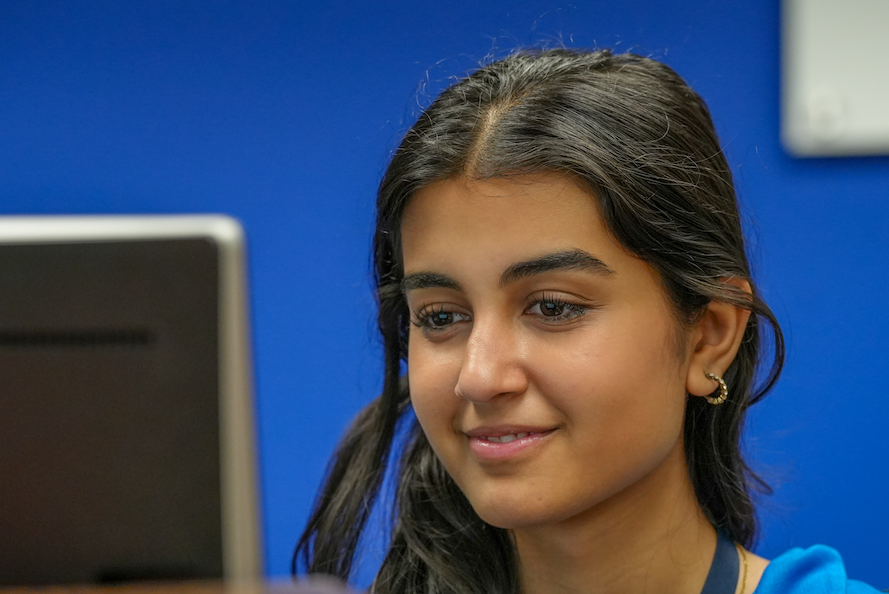 Student seated behind the counter looking toward a customer.