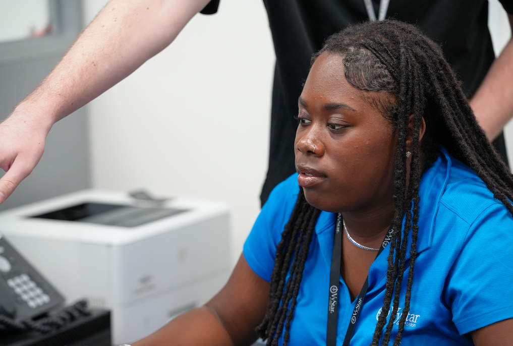 Student helping a peer at the credit union counter.