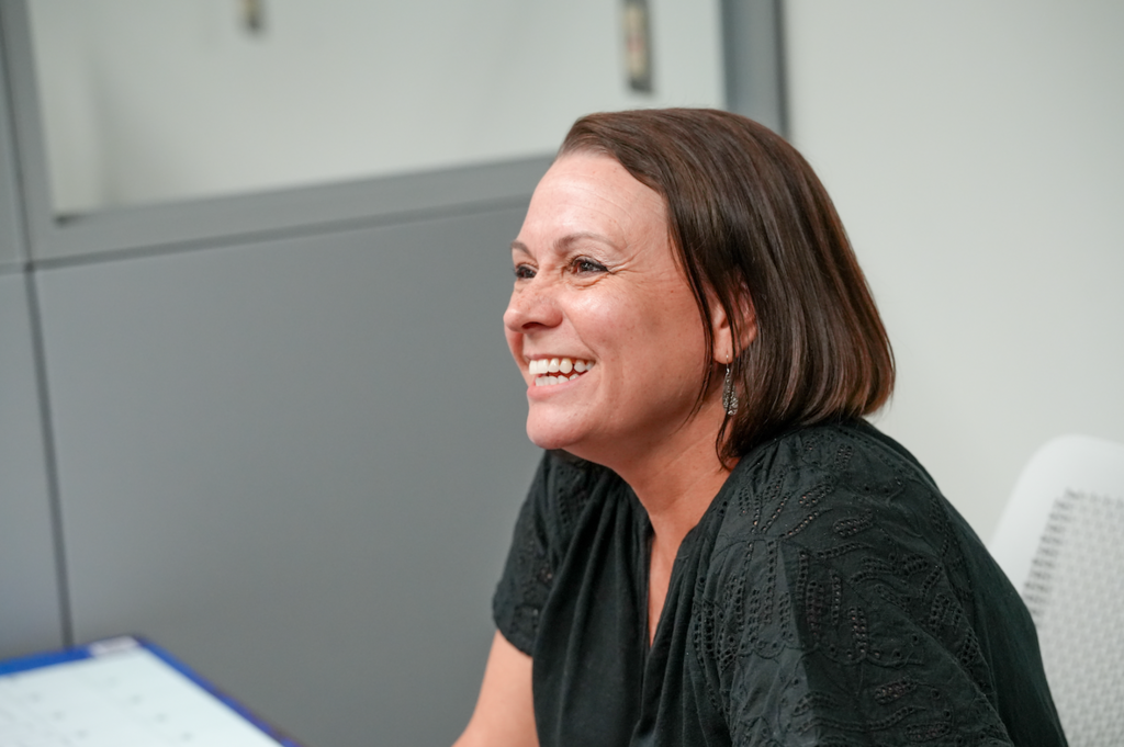 Rebeccah Campbell, Lead Teacher for the Mandarin Academy of Business, assisting students at the credit union workstation.