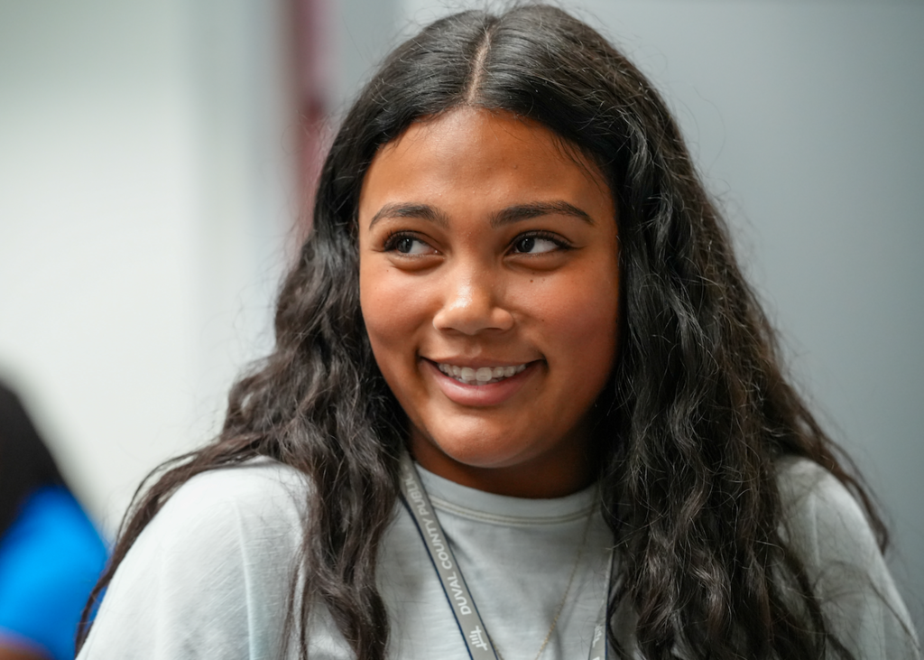 Student seated behind the counter looking toward a customer.