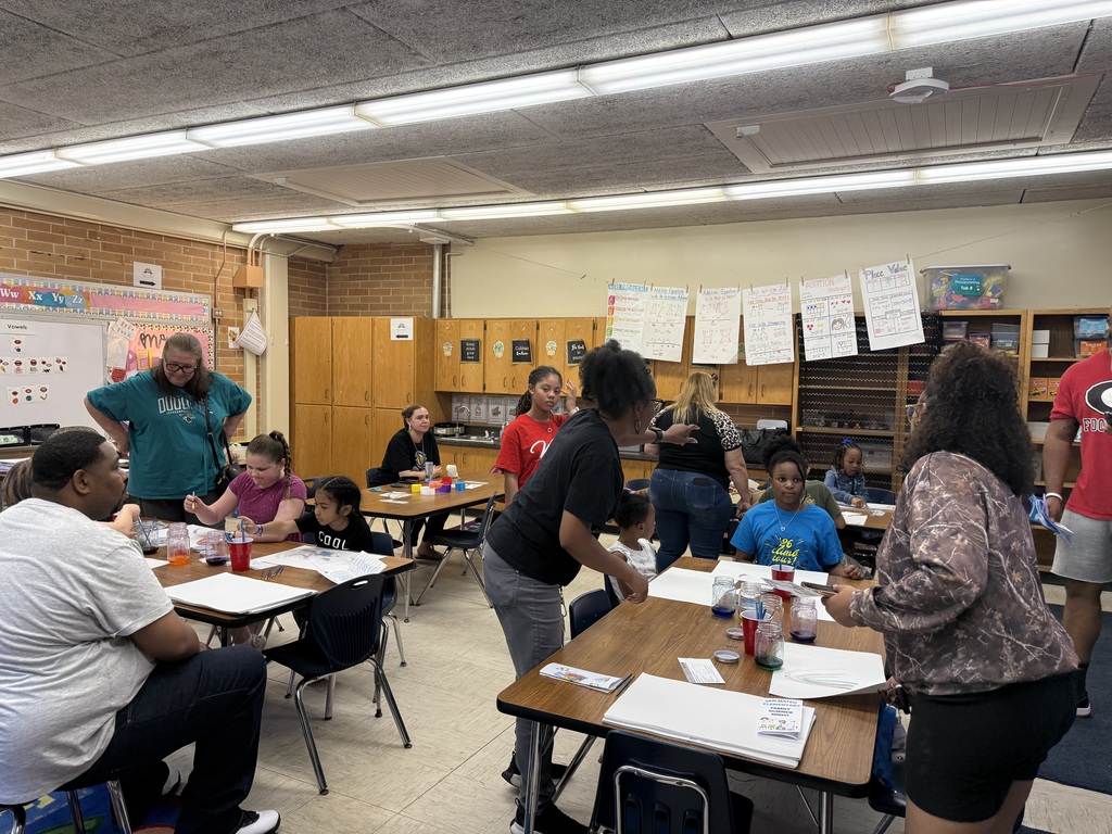 Student and parents engaged in painting with salt and evaporation  and creating windsocks. 