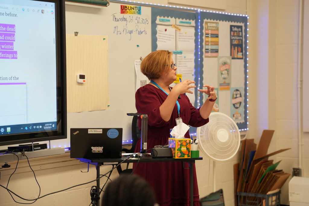 Kelly Klinger, a teacher at Stanton College Preparatory School, stands beside a student and provides guidance while the student works on a laptop in the classroom.