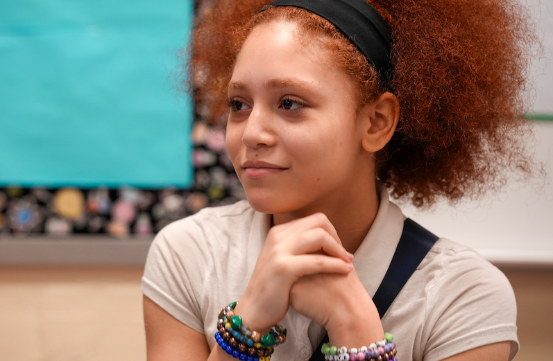 Student resting chin on hand, listening attentively in Randolph Myrie’s classroom
