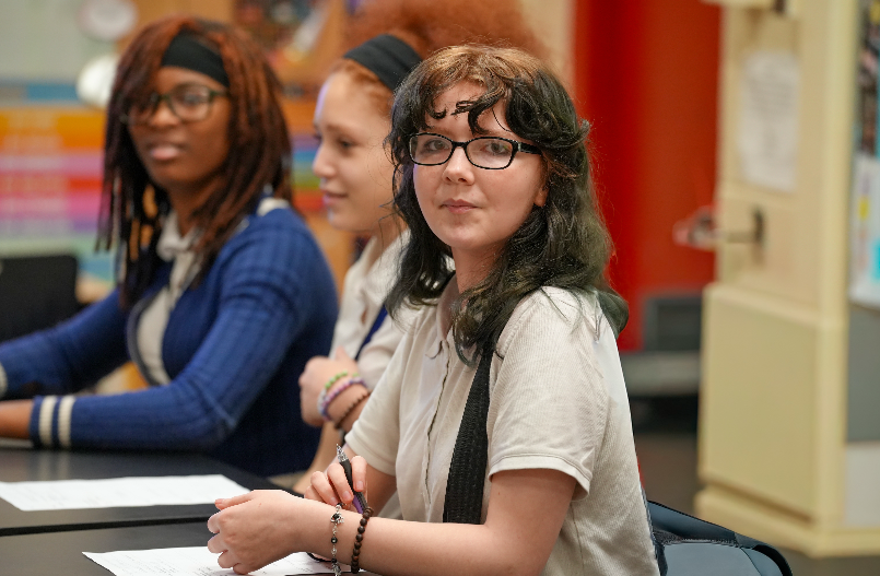 Two students engaged and smiling during an activity in Randolph Myrie’s classroom