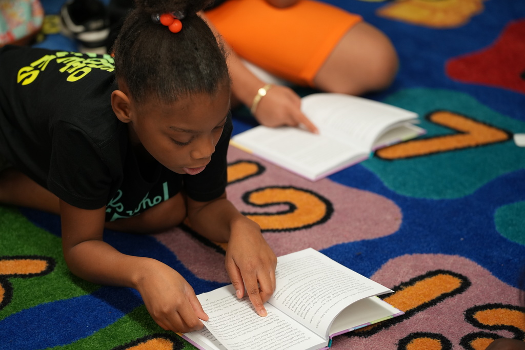Kadi Welty works with a student on a classroom activity.