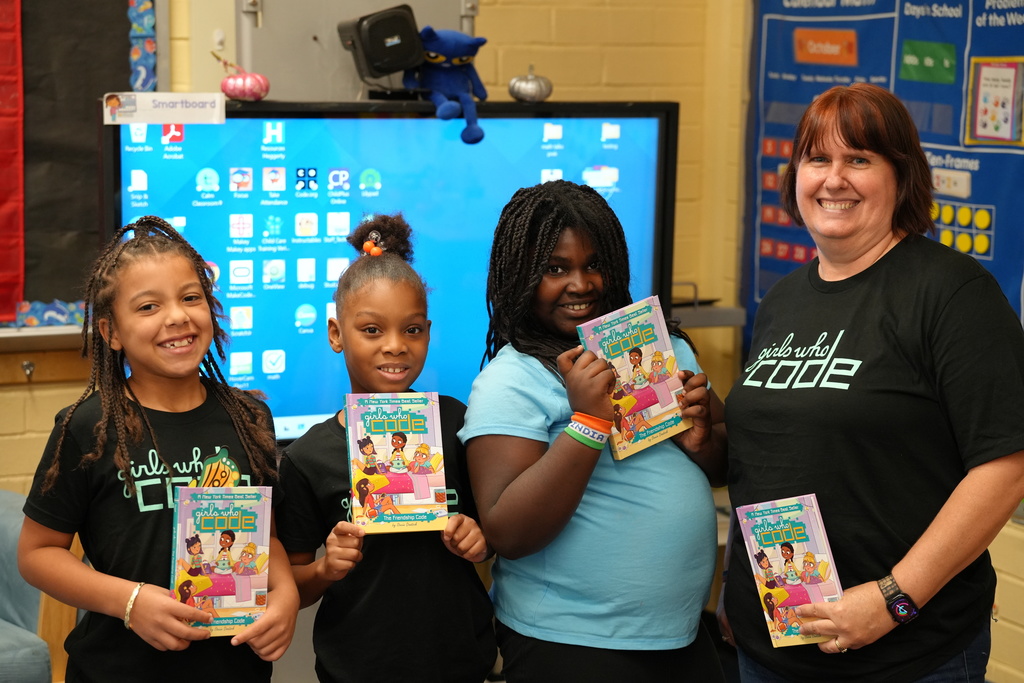 Kadi Welty and students pose together in a classroom.